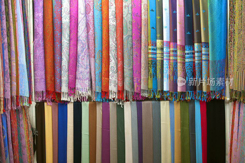 在埃及尼罗河阿斯旺省的Kom Ombo市场集市上，纺织品样品、围巾和披肩